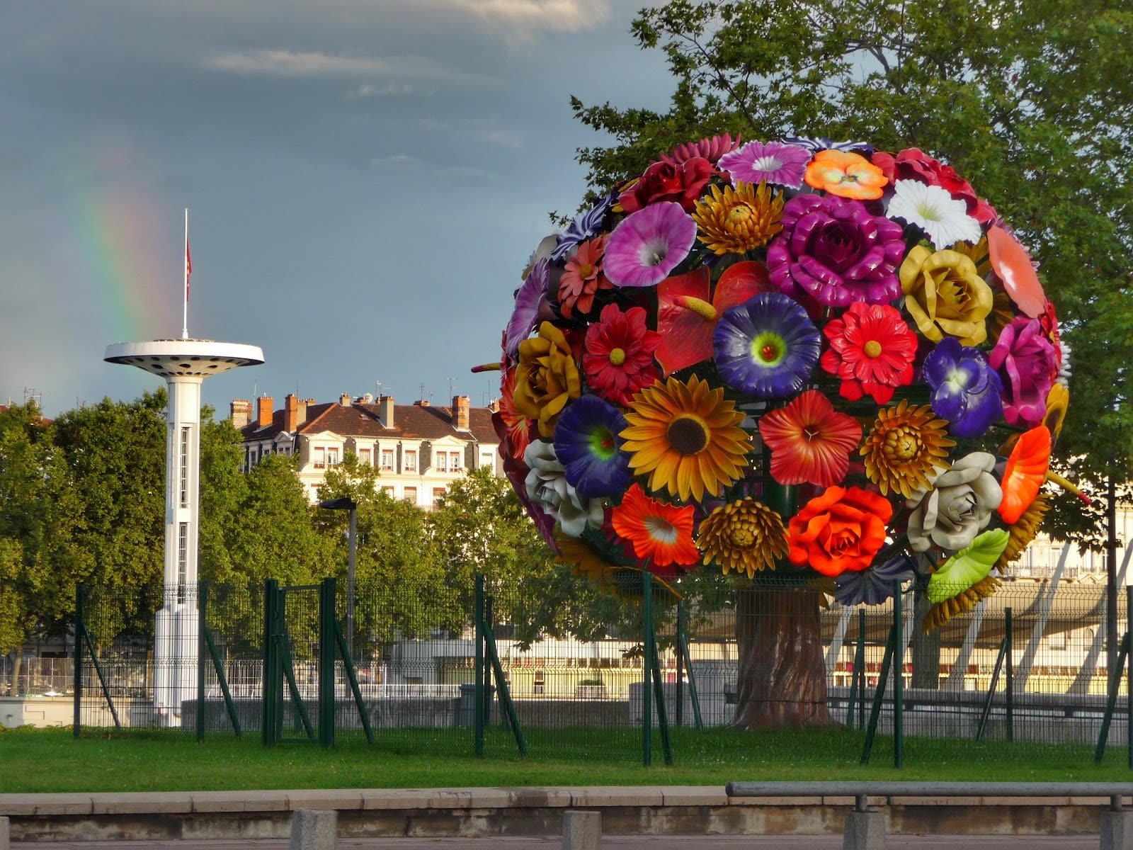 L'Arbre à Fleurs en pleine journée, sous un ciel d'orage et un arc-en-ciel, quai du Rhône à Lyon
